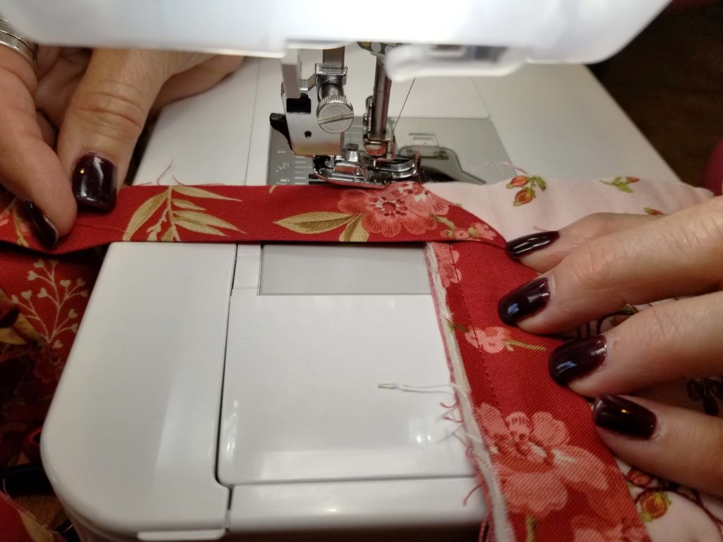 Lori demonstrates the quilt binding method she learned from her mother